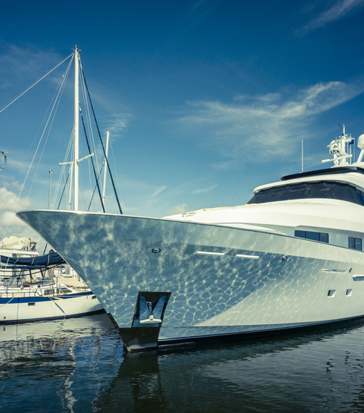 large yacht docked in the water with a sail boat behind