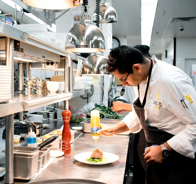 chef plating a dish in a kitchen