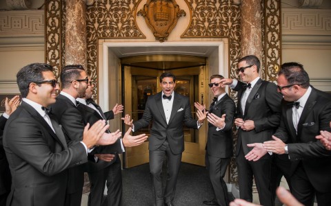 grooms walking in middle of guests