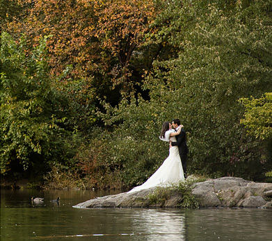 bride and groom posing by water