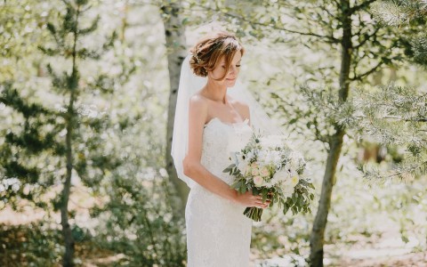 View of a beautiful bride holding her bouquet in the middle of nature