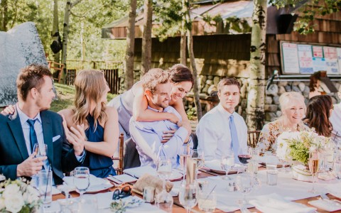 View of a group of people smiling and celebrating a wedding outdoors 