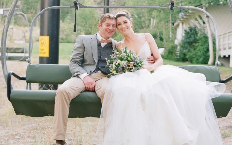 A happy just married couple sitting on a ski lift