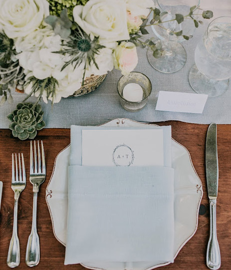 Top view of a table with a dish, a fabric napkin and some cutlery