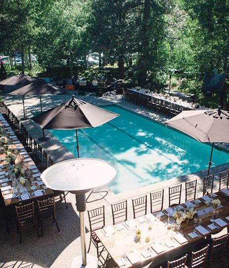 Aerial view of a big pool with some large tables around it 