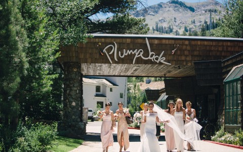 bride and brides maids walking in from of the Plumpjack sign