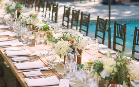 wedding decor on tables at the outdoor venue with red floral details