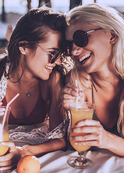 women couple smiling and drinking mimosas