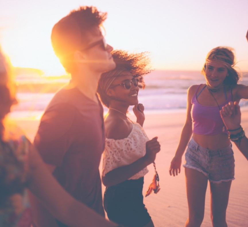 group of friends dancing together at a beachparty