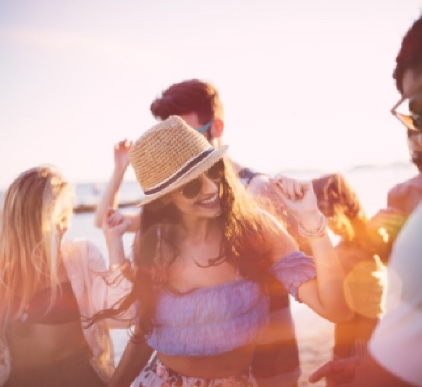 young people dancing on beach