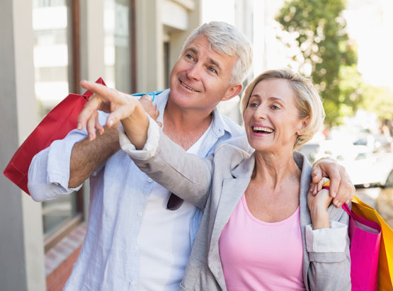 Middle age man and woman with shopping bags outside