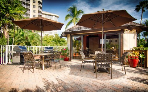 Outdoor seating area with metallic tables, chairs & umbrellas 