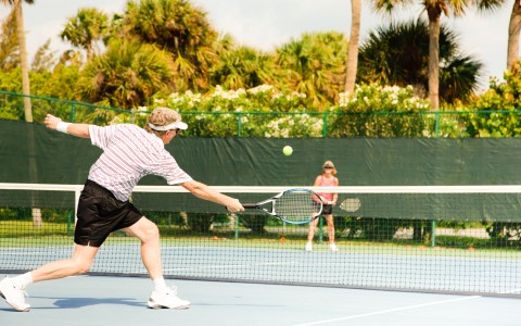 Couple playing tennis on court 