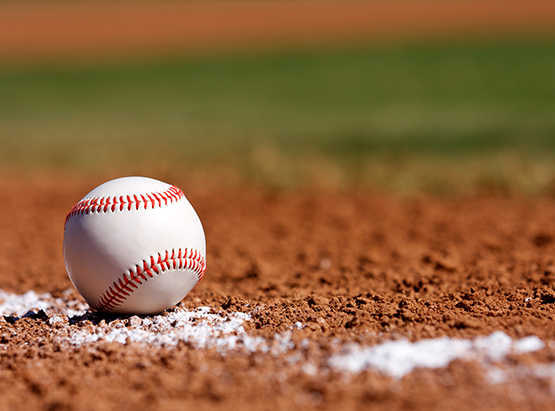 Baseball on orange field dirt