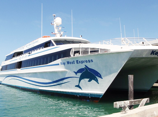 White yacht on water that has dolphin decal & says key west express 
