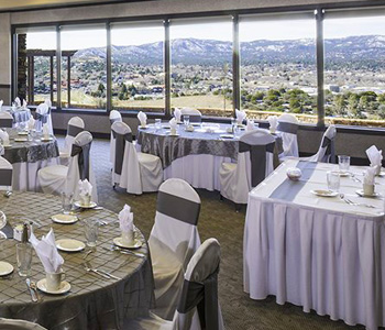 wedding venue with white linens and a large window looking over the mountains