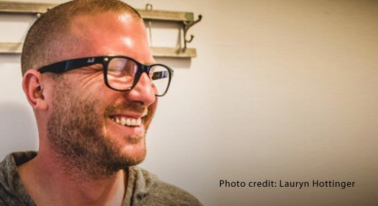 Portrait of white man laughing & wearing glasses