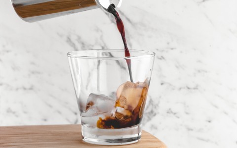 pouring espresso into a small short glass