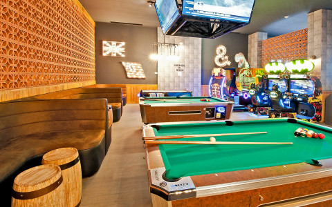 pool tables with arcade games in the back