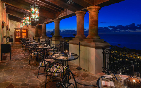 outside patio with tables overlooking ocean