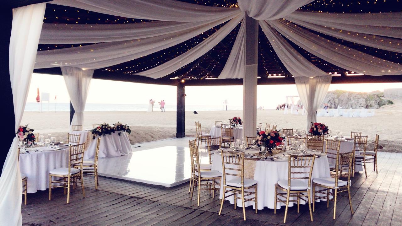 white linen in gazebo with tables on wood floor