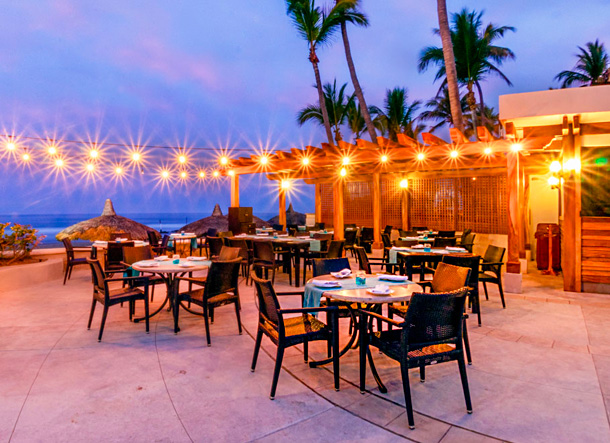 Outdoor dining area with string lights and palm trees
