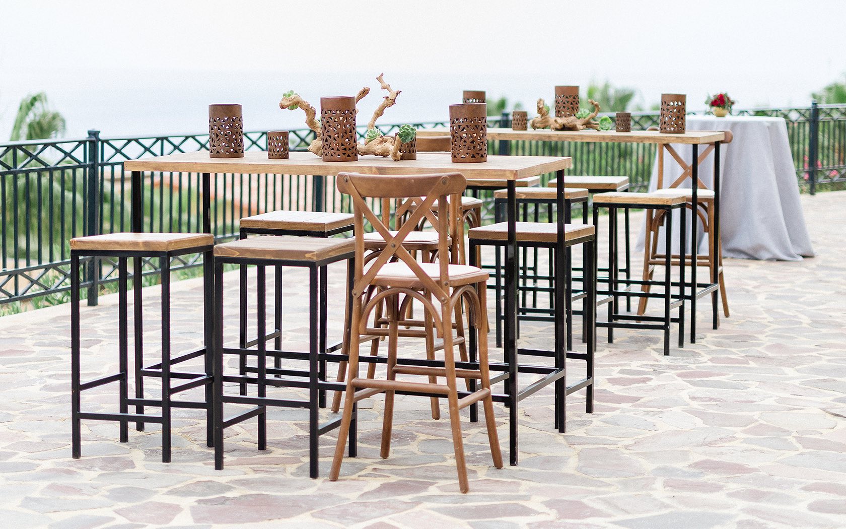 tall wooden table and chairs in outside venue