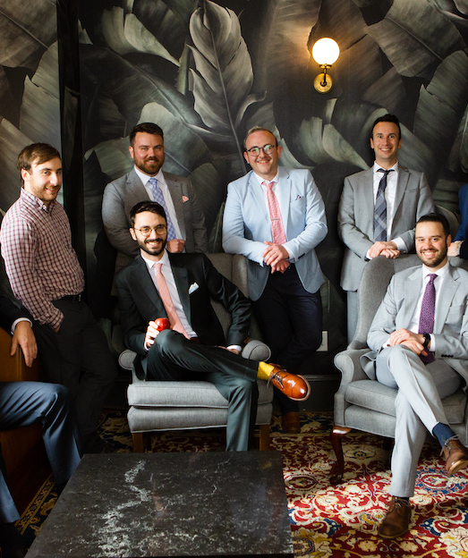 group of men sitting in chairs posing
