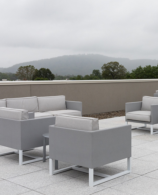 confortable chairs in a rooftop in a cloudy day with a view of the mountains 