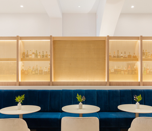 three tables and chairs aligned with a dark blue couch in the back