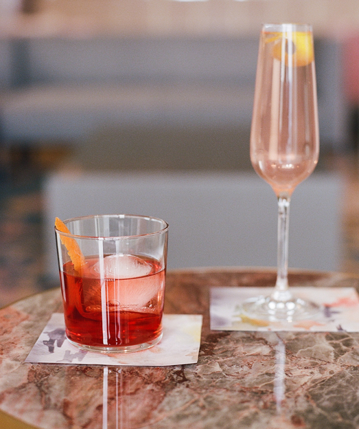champagne drink and red cocktail over a marble table 