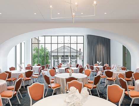 room with tables arranged with orange chairs
