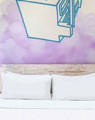 Hotel room with purple clouds painted in the wall and geometric blue house drawing 