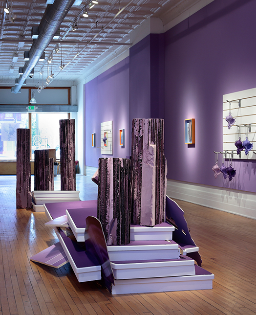 room with purple walls and sculptures in the center of the room 