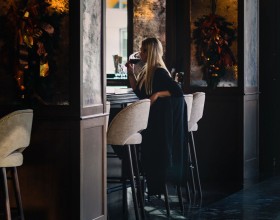 woman sitting having wine in a upscale bar