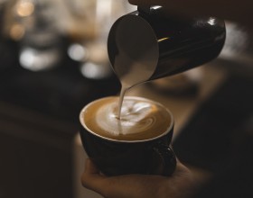 person pouring a latte
