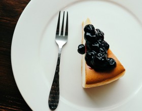 a slice of new york style cheesecake with blueberries 