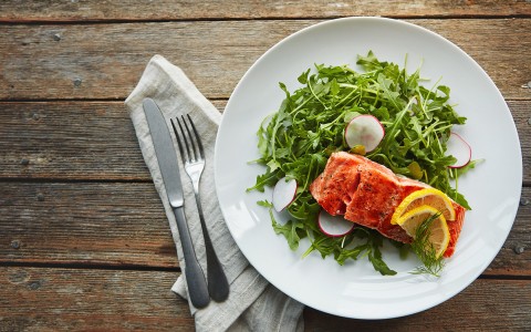 Top view of a gourmet dish with salmon, lemon and vegetables