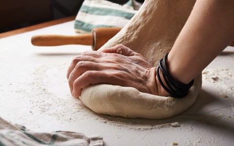 A person kneading bread dough