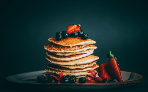 Front view of a delicious pile of pancakes with mix berries