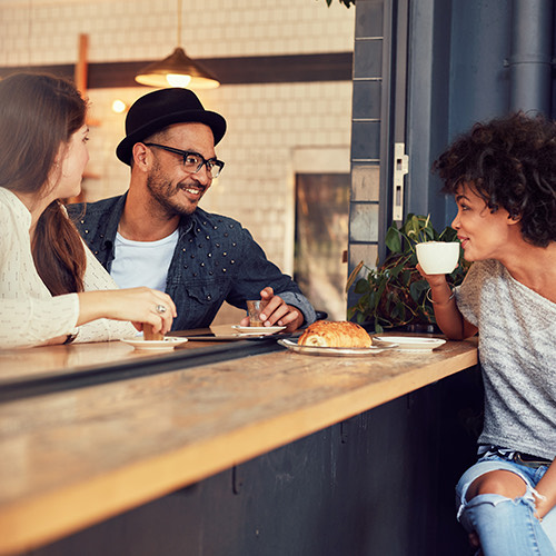 A group of friends talking and enjoying coffee and bread