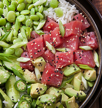 Top view of a gourmet dish with fish, vegetables, rice and avocado