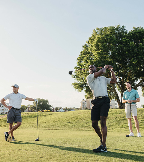 group of golfers watching another golf swing