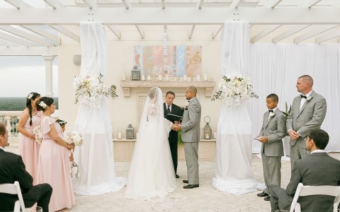 bride and groom at the altar in a bright white room