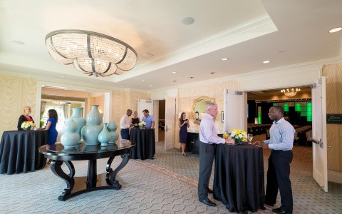 event space with people networking and small round tables