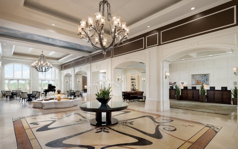 an elegant lobby with big chandeliers hanging from the ceiling