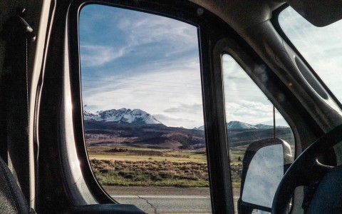 a view of the mountains in colorado from the window of the driver seat in the van