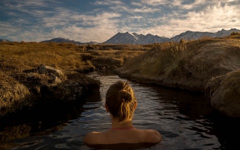 back of person's head sitting in a river