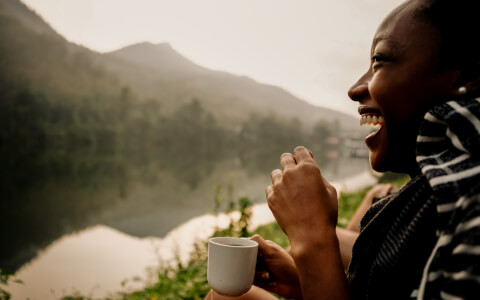 person having coffee in the mountains