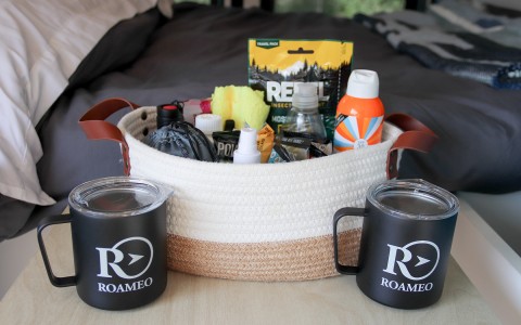 two roameo mugs next to a ready prepared basket with trinkets 
